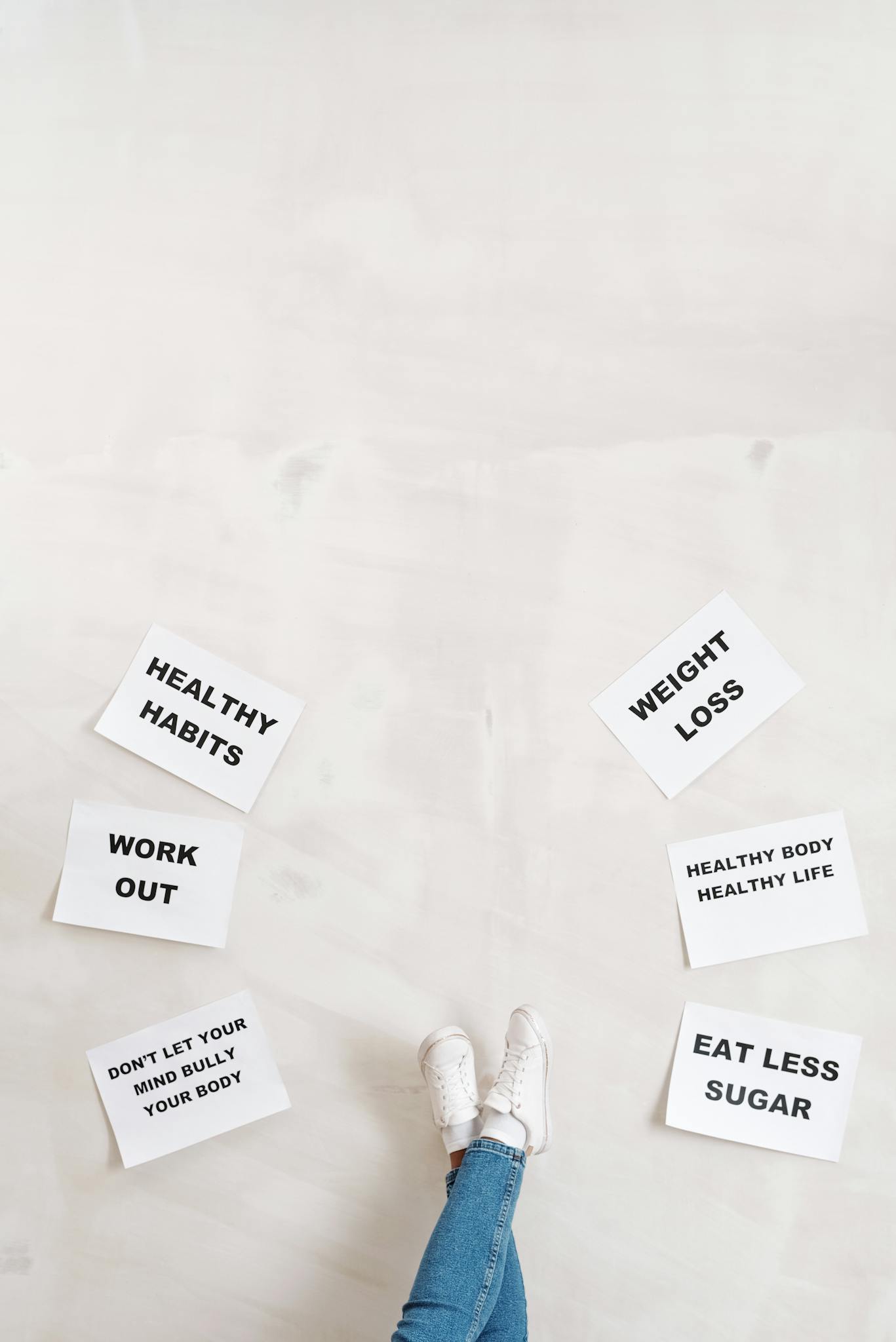 Overhead view of motivational boards inspiring healthy lifestyle with casual denim and sneakers.